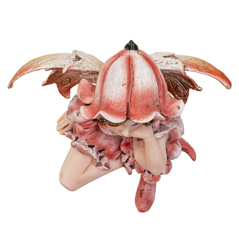 Fairy figurine, pink dress, wings and flower hat. Blond-streaked brown hair with golden yellow-brown eyes. Top down view