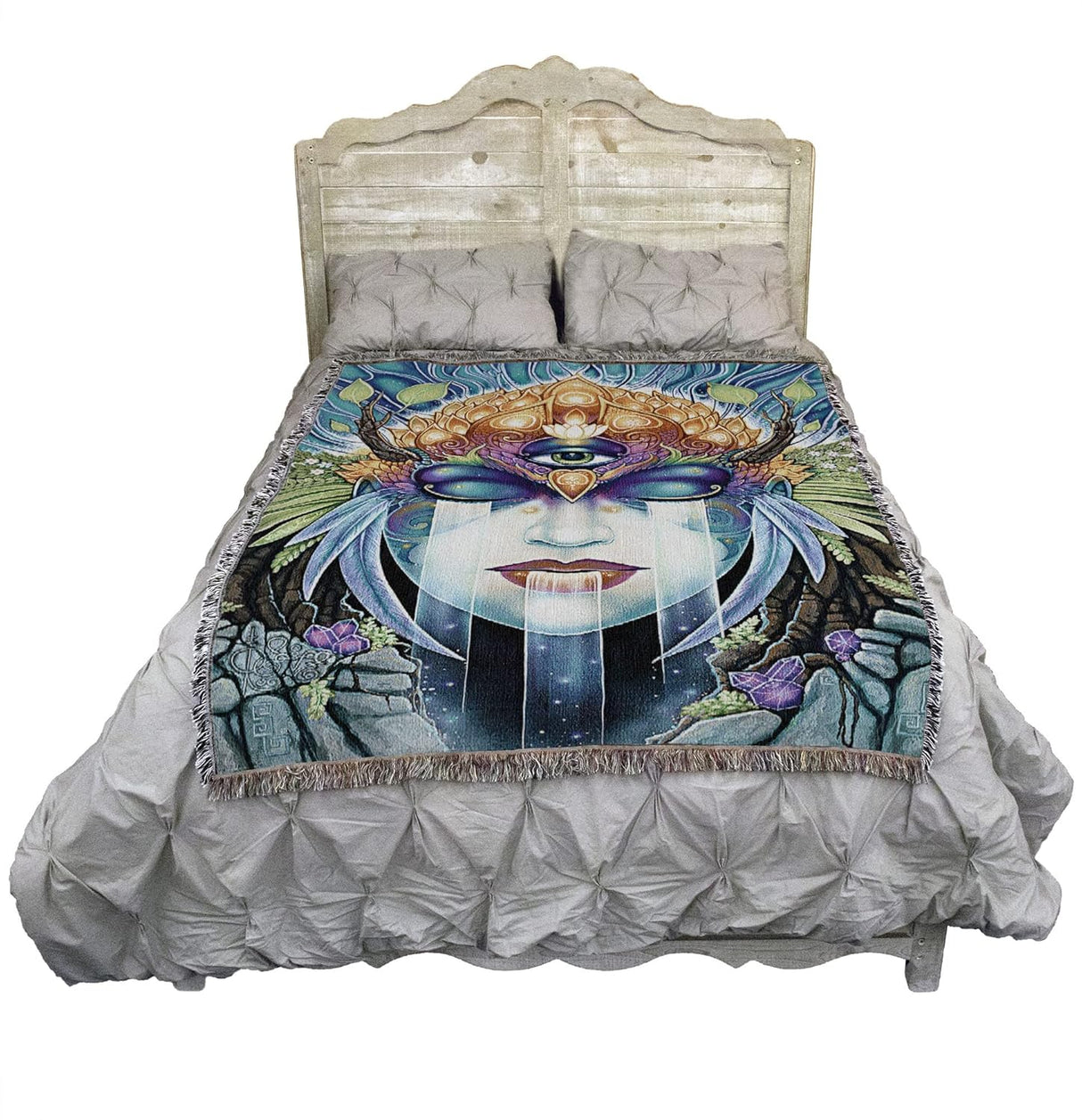 Gaia face tapestry blanket shown draped over a bed