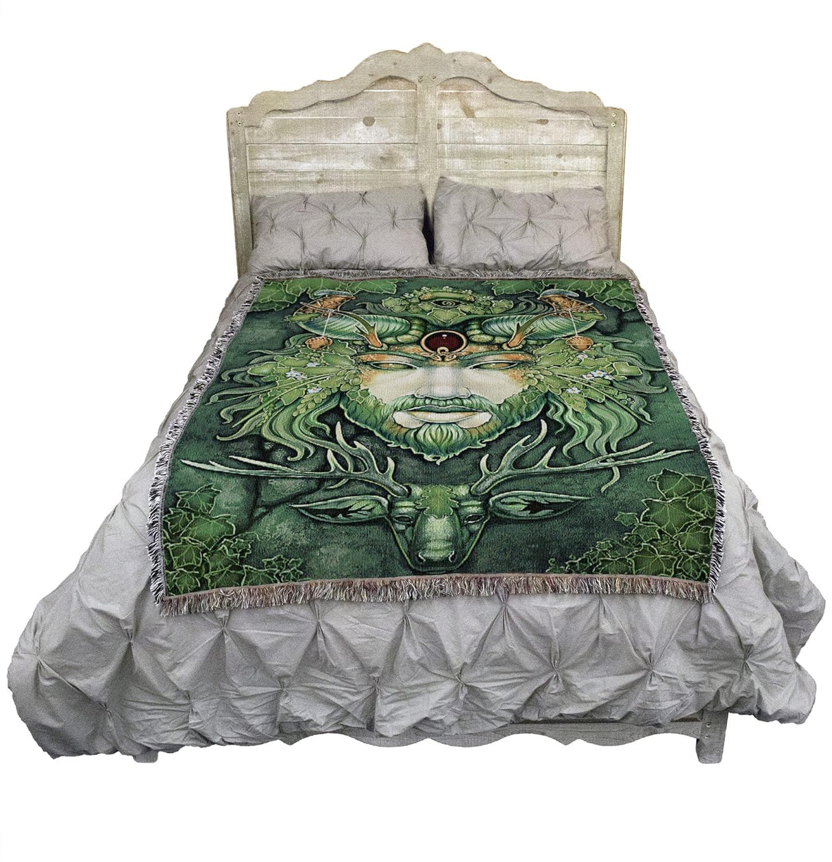 Tapestry blanket of Greenman's antlered face with leaves and a stag below him, ivy leaf border, shown on a bed