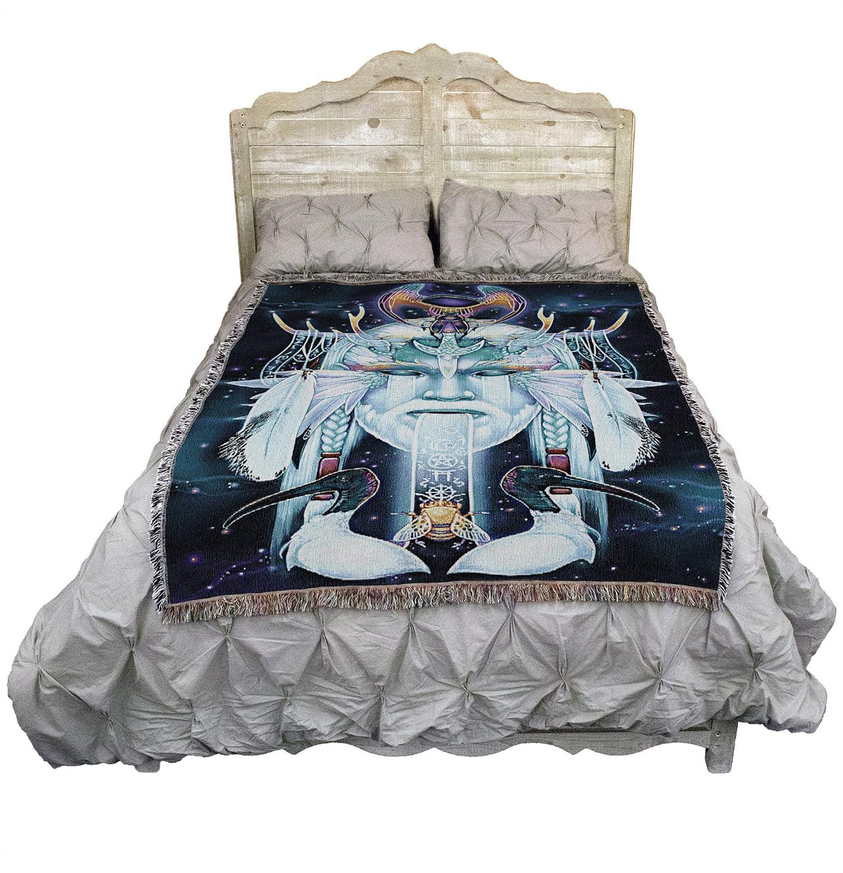 Tapestry blanket with face of an air god, birds, bee, symbols, shown on a bed