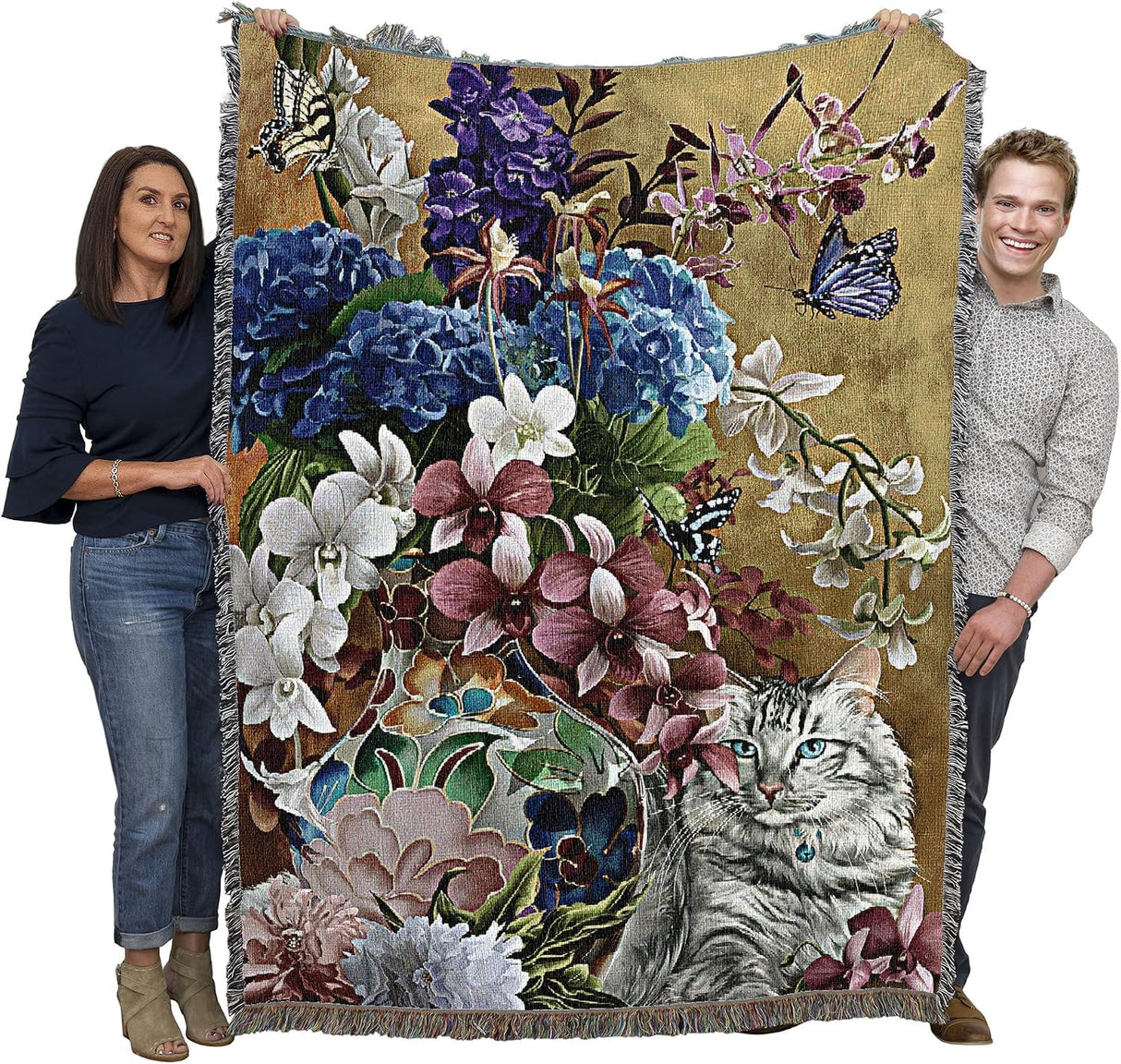 Tapestry blanket with blue eyed gray tabby cat and floral arrangement in a vase with butterflies. Shown held by two adults