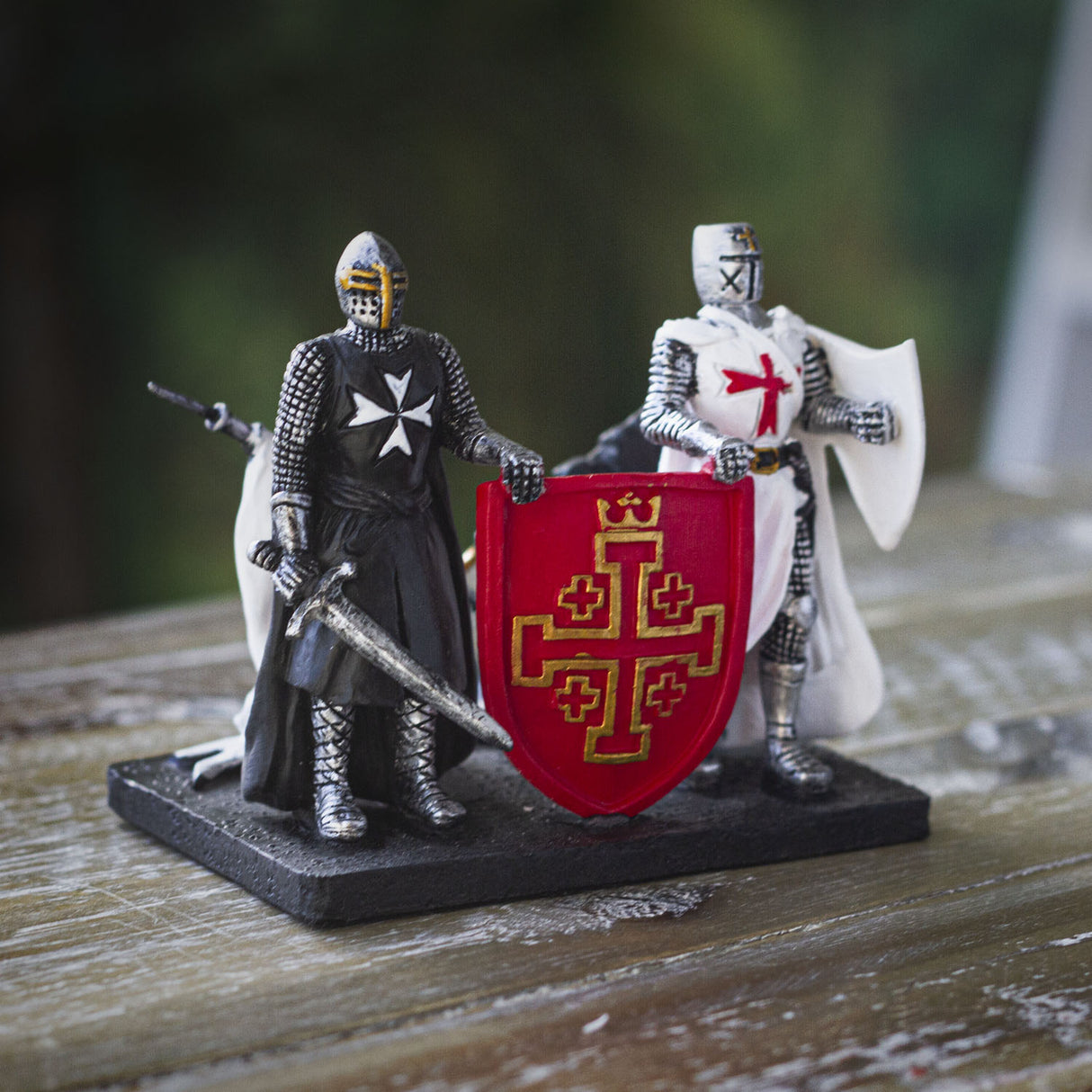 Figurine and card holder with two knights (one in black and one in white) holding up a red shield.