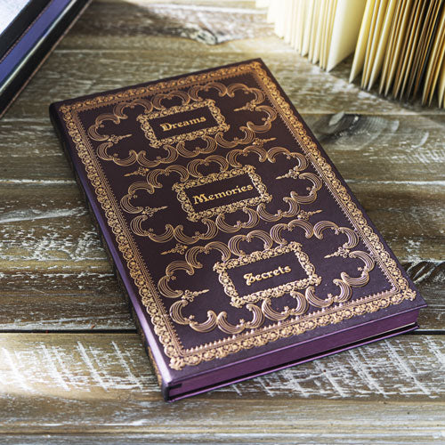 Journal with cover in dark red-brown and gold embossed, words "Dreams", "Memories", and "Secrets"