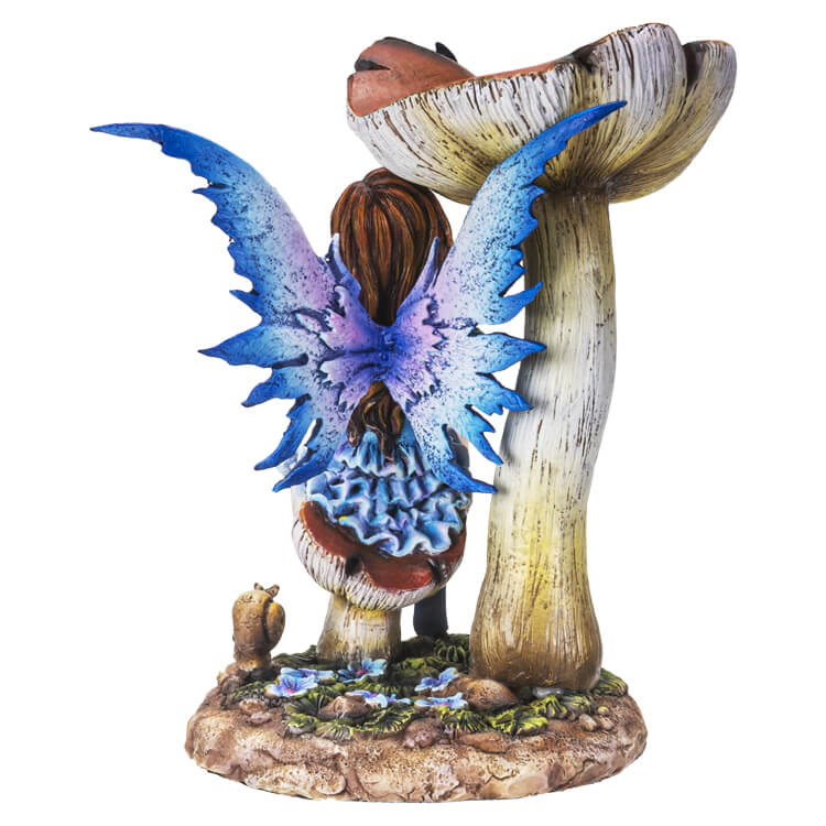 The statue shows a fairy sitting on a toadstool. She wears a dress of ruffled blue, and has indigo wings to match. A butterfly perches on her hand, and another purple flutterby sits on a taller mushroom.