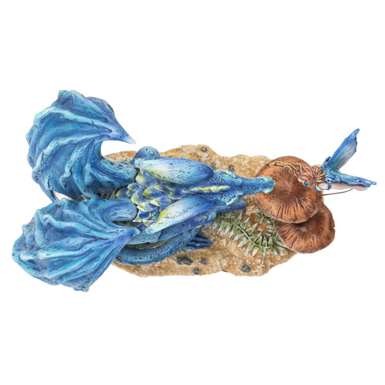 Figurine of a blue dragon and a fairy hovering with blue wings above mushrooms. Top down view