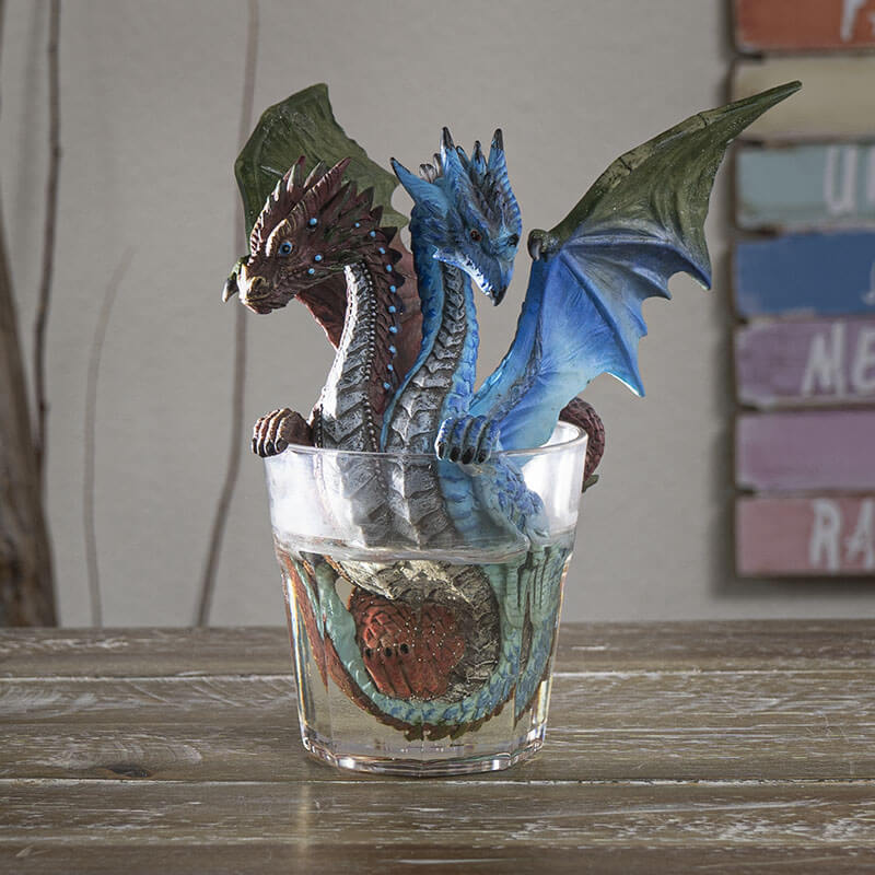 Two headed gin & tonic dragon with blue and brown heads, sitting in glass of clear resin drink