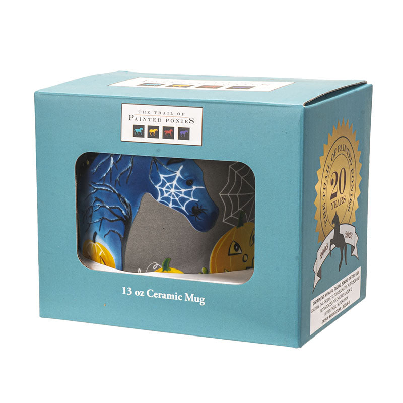 A gray ceramic mug with a white handle and interior, decorated with a Halloween design featuring a blue horse with spiderwebs, orange jack-o'-lantern pumpkins, white cobwebs, and other spooky details, shown boxed
