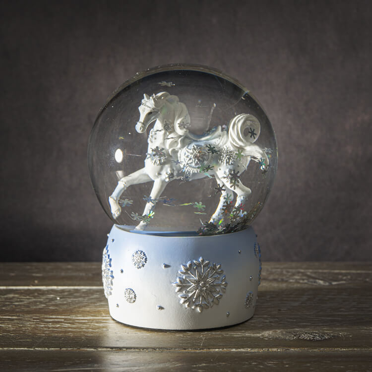 Snowglobe with white horse and silver snowflake accents, and snow glitter inside