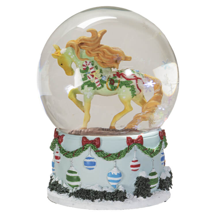 Snowglobe with festive ornament holiday pony inside and iridescent snowflake glitter. Base has holiday ornaments