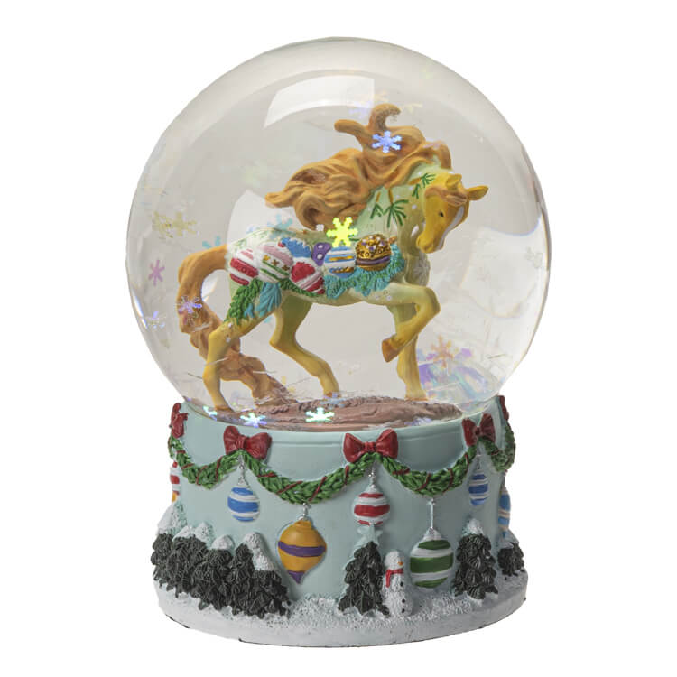 Snowglobe with festive ornament holiday pony inside and iridescent snowflake glitter. Base has holiday ornaments