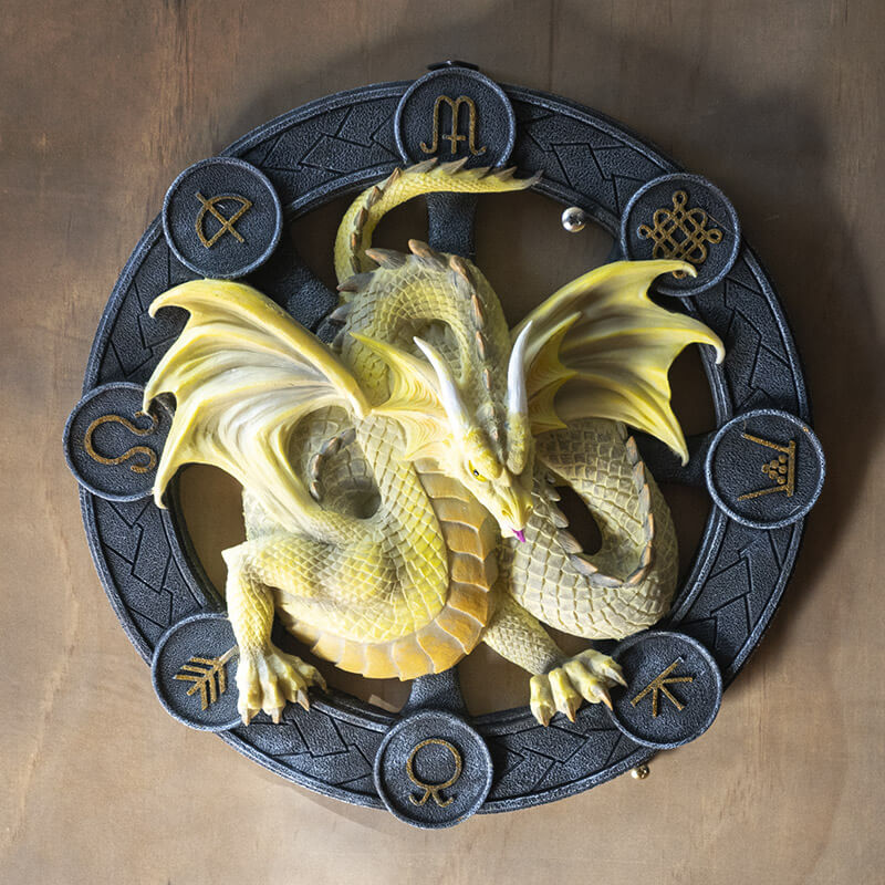 Yellow Mabon dragon on a black wheel with gold symbols
