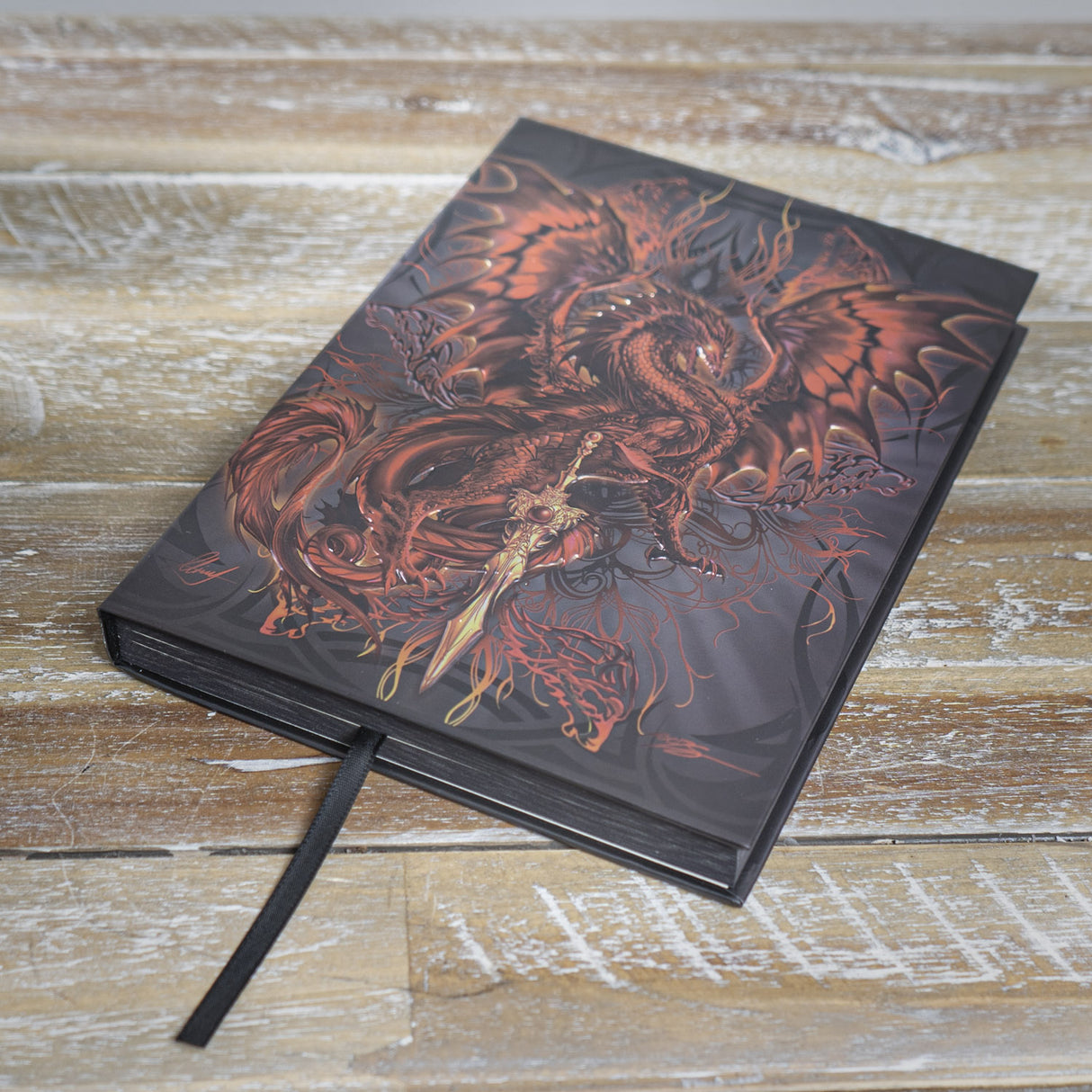Journal with cover art by Ruth Thompson, rusty brown dragon with golden sword