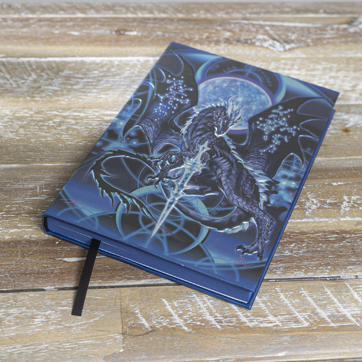 Journal, cover art by Ruth Thompson - blue black dragon with constellations on wings in front of full moon with glowing sword