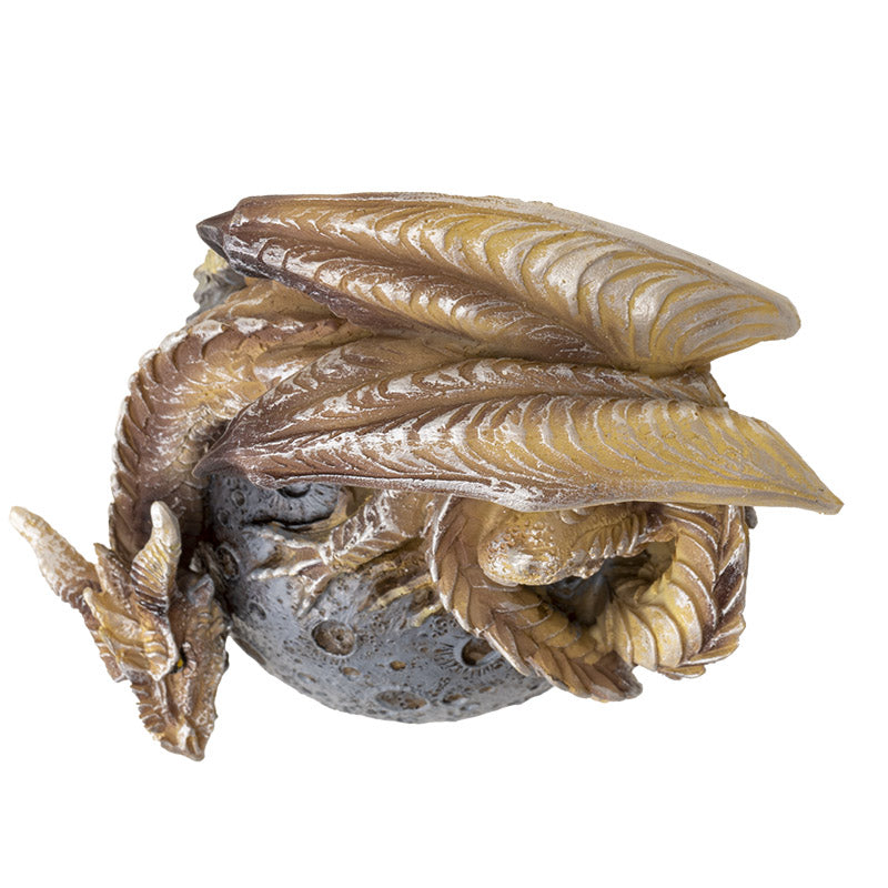 Figurine of a tan dragon on a gray moon orb, shown top down