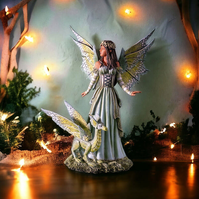 Figurine of a fairy dressed in green with matching wings and dragon. She has tanned skin and braided brown hair.