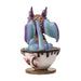 Figurine of a blue and purple dragon with big eyes sitting in a drippy cup labeled "Latte" in red, shown from the back