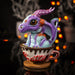 Figurine of a blue and purple dragon with big eyes sitting in a drippy cup labeled "Latte" in red