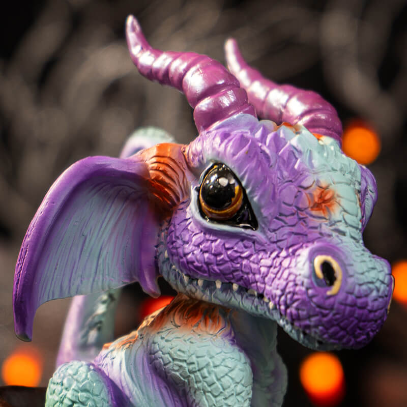 Closeup of dragon's face, purple and blue with red accents and big brown eyes