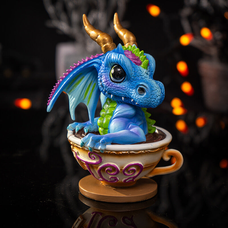 Figurine of blue, purple, green dragon with gold horns sitting in a cup of tea