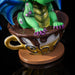 Closeup of mug with "Chai" written, green dragon with purple claws