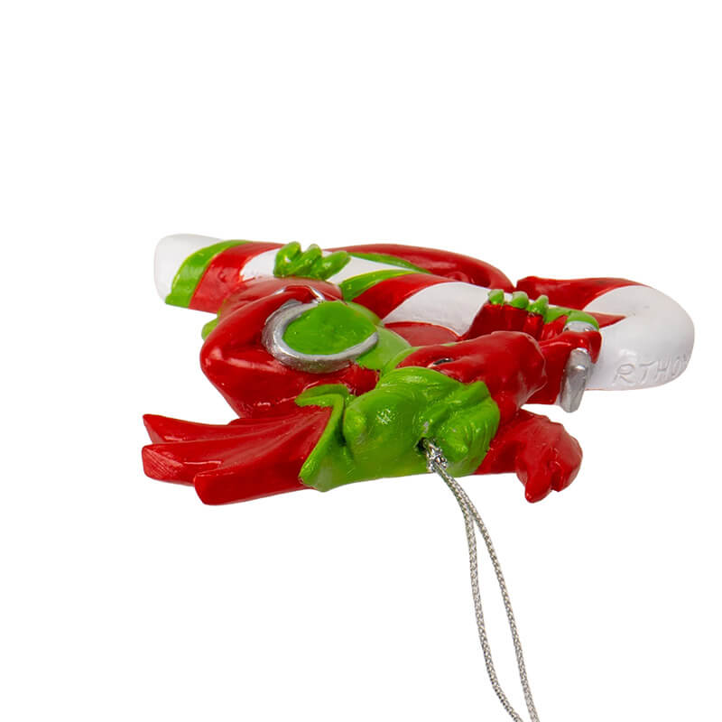 Ornament with red and green dragon painting stripes onto a candy cane