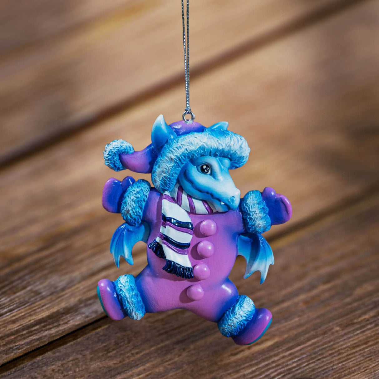 Blue dragon ornament in a purple snow suit with hat and scarf