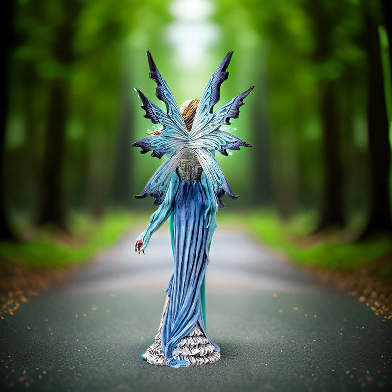 Fantasy fairy figurine with blue wings and dress holding a baby bird, shown from the back