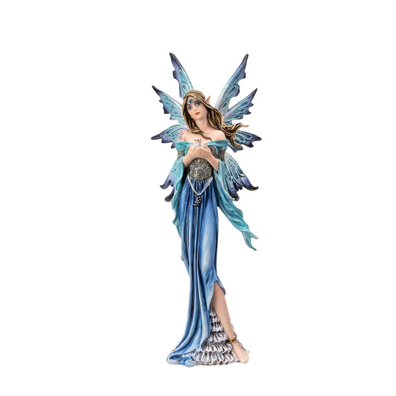 Fantasy fairy figurine with blue wings and dress holding a baby bird