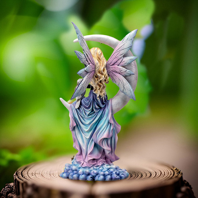 Fairy statue with a crescent moon and owl. Fairy has blue-purple-pink dress and blond hair, shown from the back