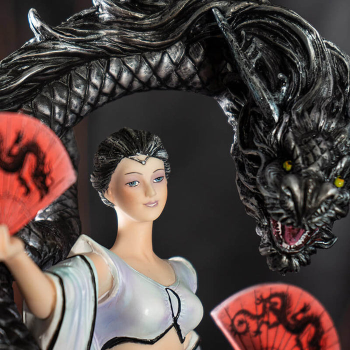 Closeup of woman dancer, pale skin, white dress, black hair and black dragon. She has red fans.