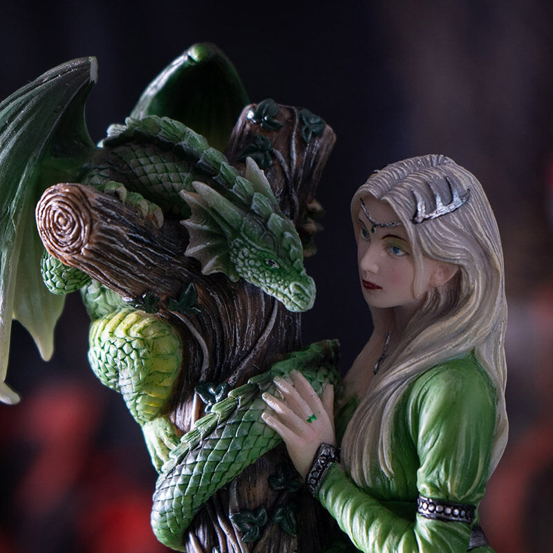 Closeup of blond princess in green dress with emerald dragon on tree