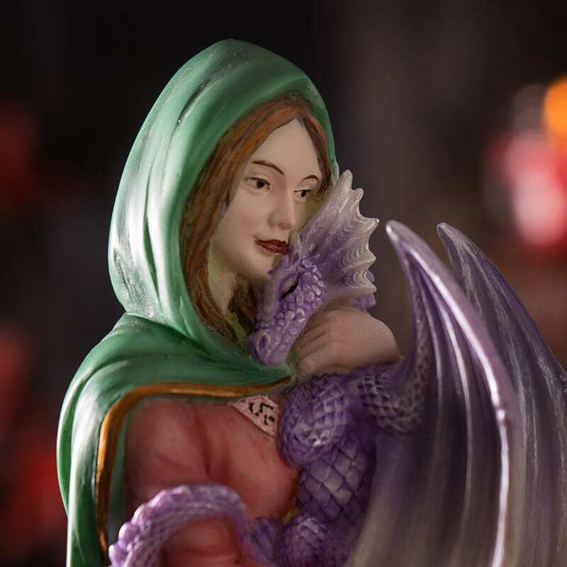 Close up of woman cuddling purple dragon