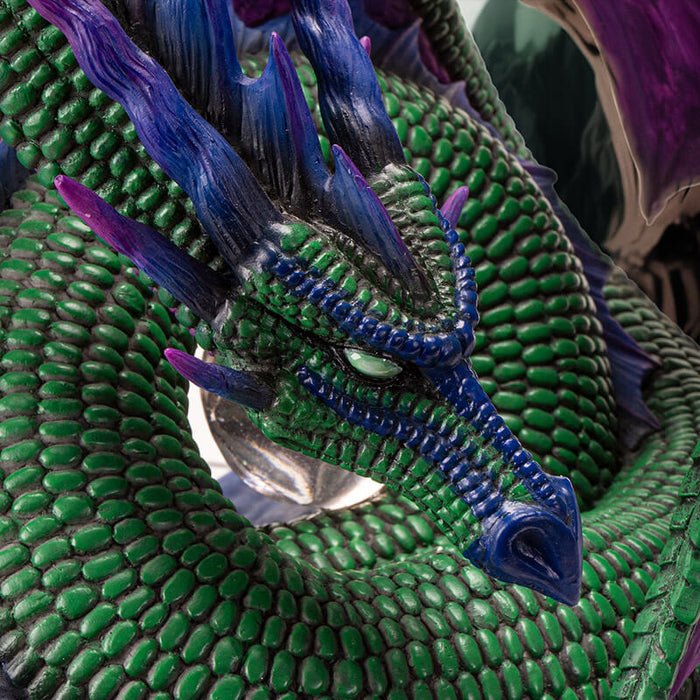 Closeup of green dragon's face with blue-purple accents.