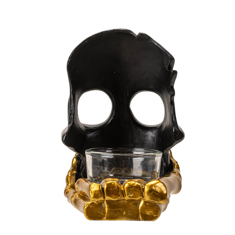 Black skull with golden boney hand candleholder, shown from the back