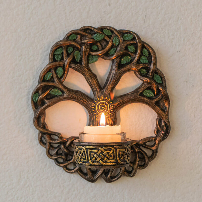 Tree of Life candleholder wall plaque with Celtic knot designs and spiral, shown with glowing candle