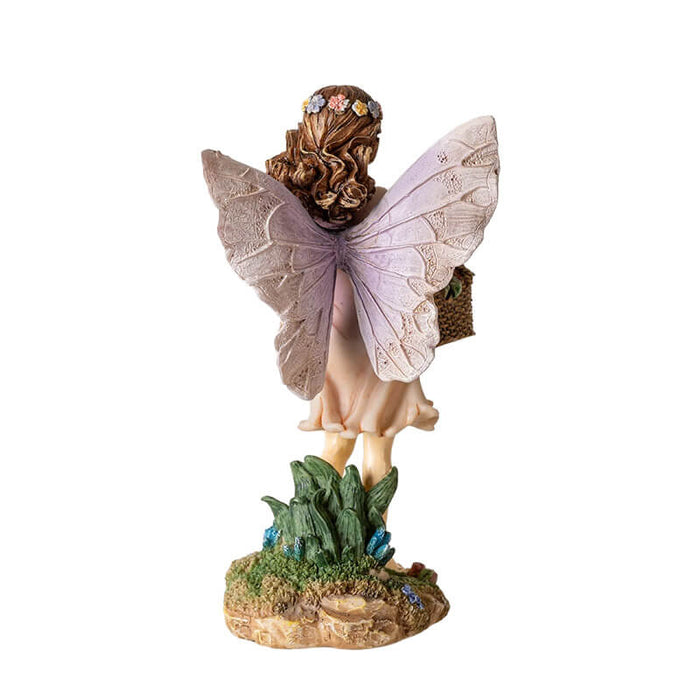 Fairy figurine of pixie with basket full of fruit, holding one. Brown hair, flower corn, pale pink dress & wings