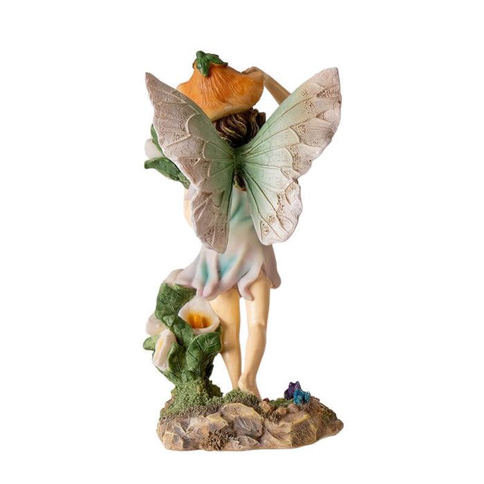 Figurine of fairy with brown hair and pastel dress and wings, with calla lily flowers, shown from the back