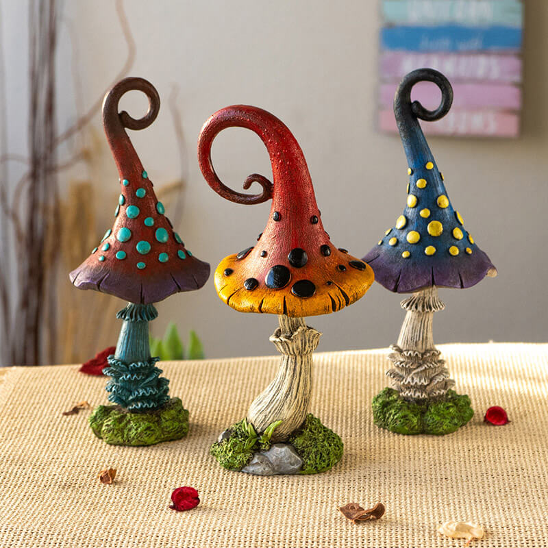 Set of three mushroom figurines. One is burgundy and purple with blue dots and stem, one is red and yellow with black dots, third is blue and violet with yellow spots.