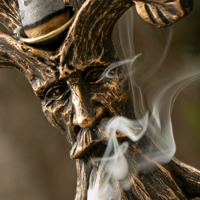 Tree of Life backflow cone incense burner with greenman face in faux-bronze. Closeup of mouth with incense smoke