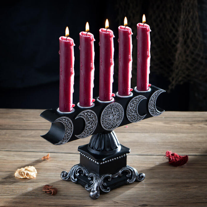 Candle holder with space for five candles. Silver moons and pentagram on black base. Shown with red candles (not included)