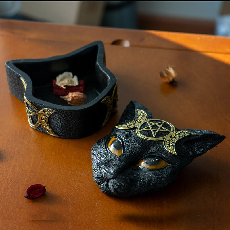 Trinket box shaped like a black cat head, orange eyes and gold triple moon designs.