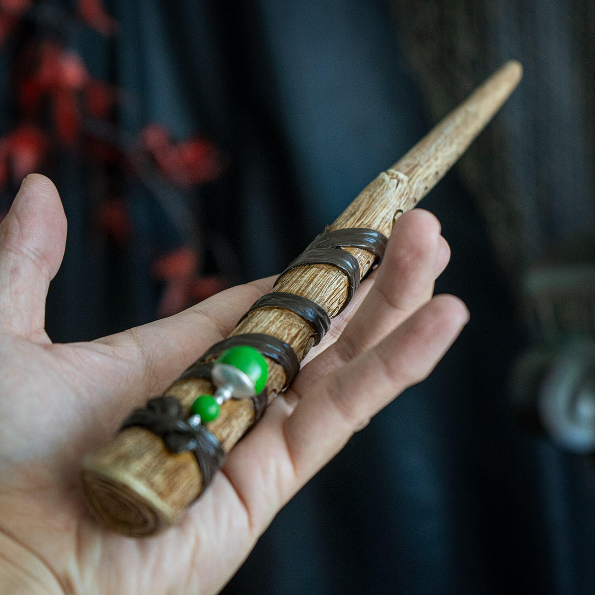 Magic wand in faux wood banded with ribbon accents, baubles and carved with runes.