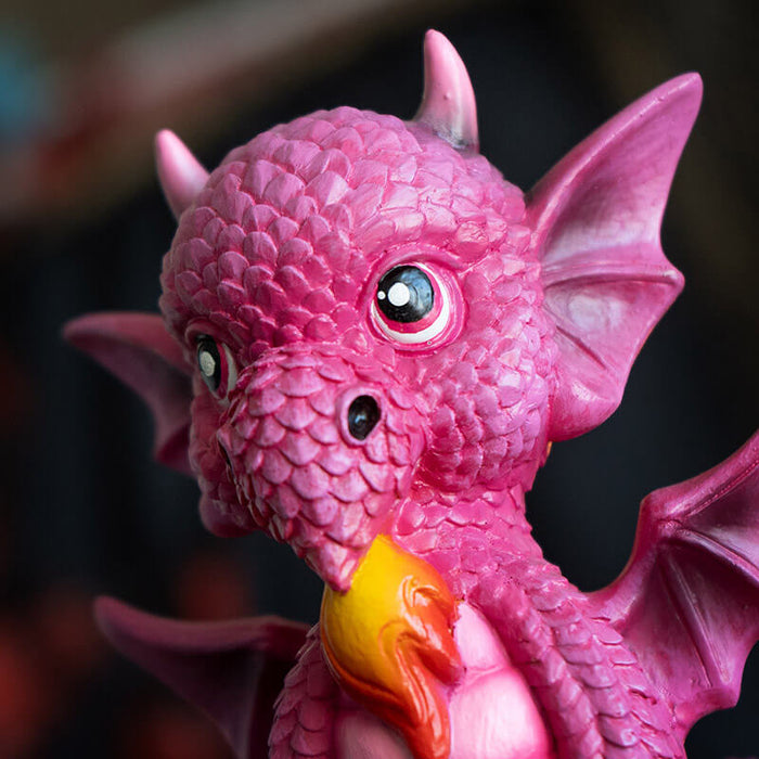 Figurine of pink dragon with fire sitting on base that says "A Princess With Her Own Dragon!" Closeup of face