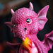 Figurine of pink dragon with fire sitting on base that says "A Princess With Her Own Dragon!" Closeup of face