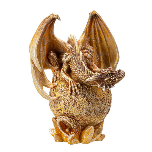 Figurine of tan dragon perched on golden Venus planet with crystals underneath