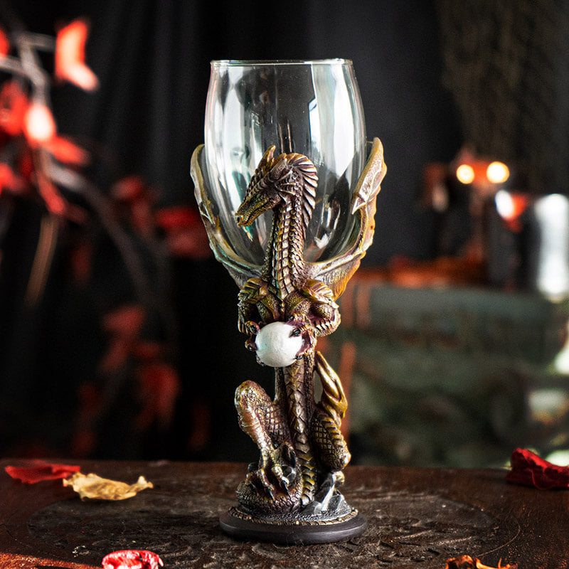 Goblet with glass at the top, dragon in shades of orange/brown holding a pearl makes up the stem