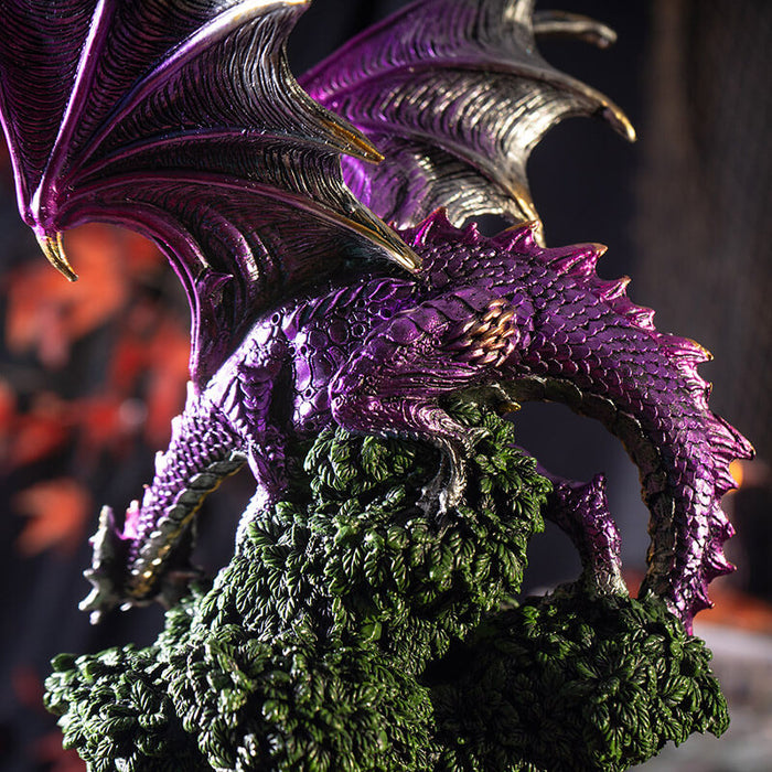 Figurine of a metallic purple dragon perched on a green tree