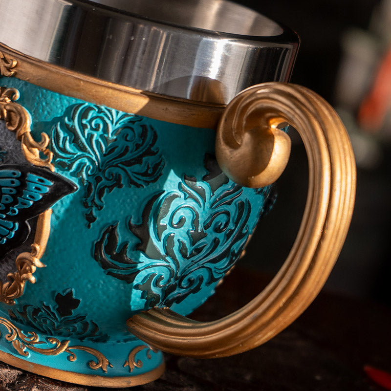 Teacup with blue moth and faux-gold filigree, stainless steel insert