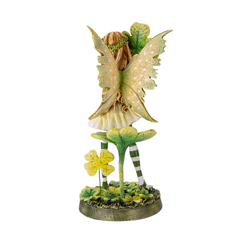 Figurine of a fairy wearing a green dress with four leaf clovers and striped stockings, back view