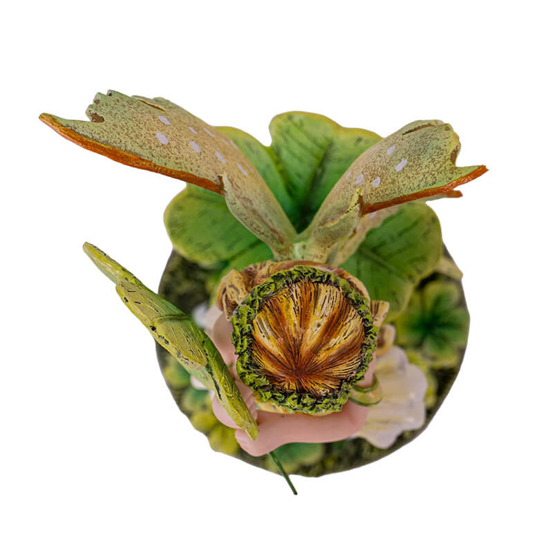 Figurine of a fairy wearing a green dress with four leaf clovers and striped stockings, top down